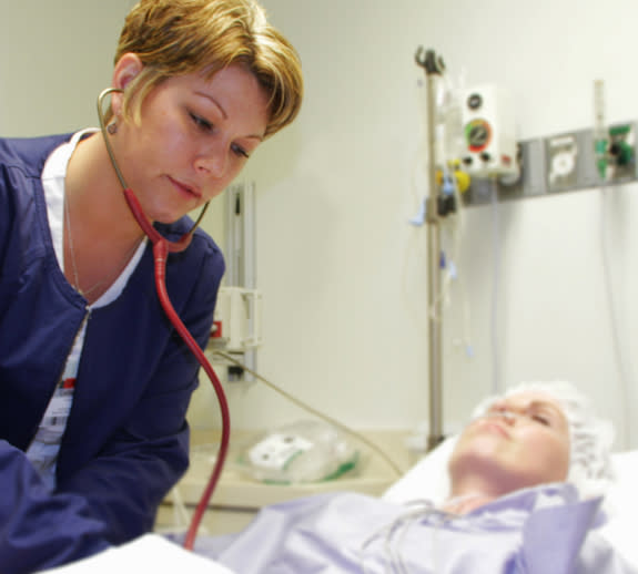 Callie Earliwine checks on a patient at Ohio Valley Medical Center in West Virginia where she works as a critical care nurse. Earliwine recently suffered a minor stroke while at work, and though there were plenty of warning signs, she didn't re