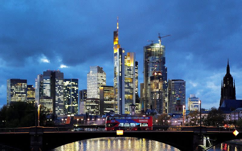 FILE PHOTO: A double decker bus passes the skyline with its dominating banking district in Frankfurt