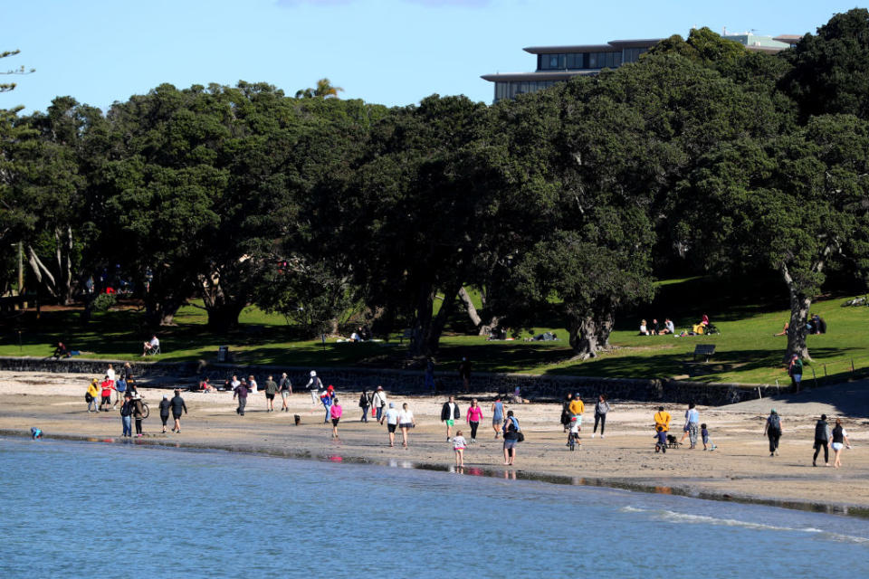 Members of the public walk along Takapuna beach in Auckland. Source: Getty 