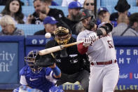 Arizona Diamondbacks' Christian Walker, right, hits a solo home run as Los Angeles Dodgers catcher Austin Barnes, left, and home plate umpire Larry Vanover watch during the second inning of a baseball game Monday, May 16, 2022, in Los Angeles. (AP Photo/Mark J. Terrill)
