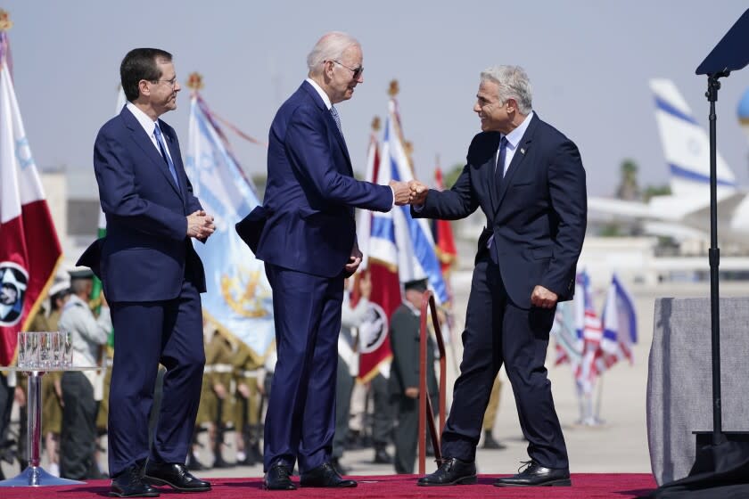 President Joe Biden is greeted by Israeli Prime Minister Yair Lapid, right and President Isaac Herzog, left, as they participate in an arrival ceremony after Biden arrived at Ben Gurion Airport, Wednesday, July 13, 2022, in Tel Aviv. (AP Photo/Evan Vucci)