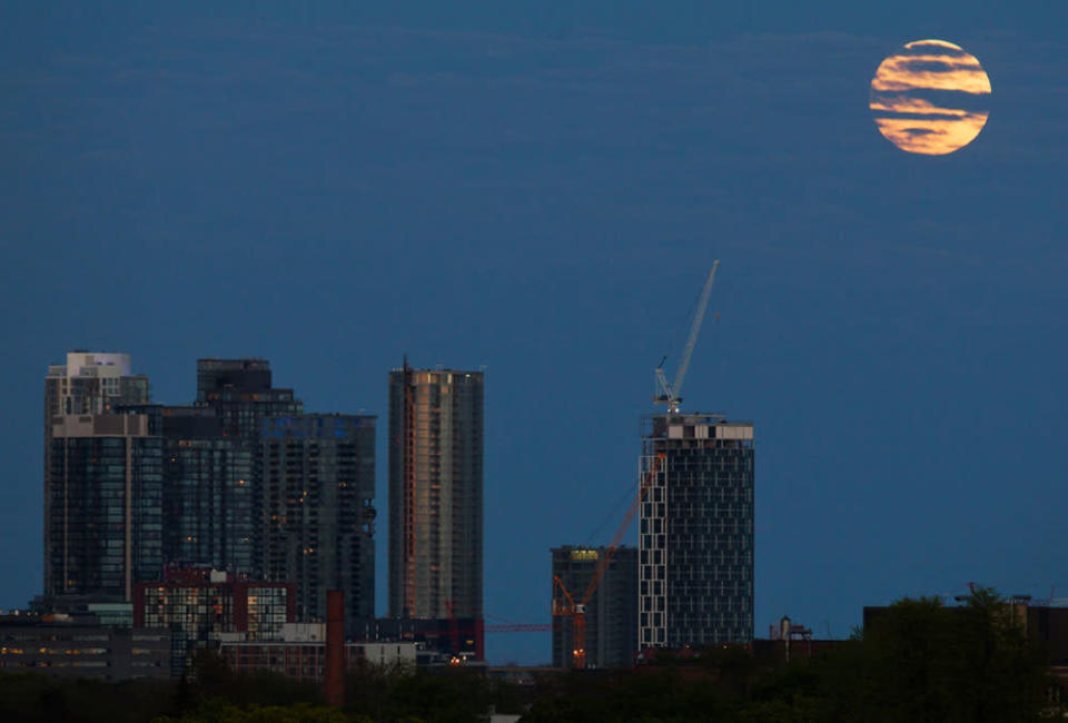 The "supermoon" rises over some apartment buildings in Toronto, May 5, 2012. A "supermoon" will light up Saturday's night sky in a once-a-year cosmic show, overshadowing a meteor shower from remnants of Halley's Comet, the U.S. space agency NASA said. The Moon will seem especially big and bright since it will reach its closest spot to Earth at the same time it is in its full phase, NASA said.