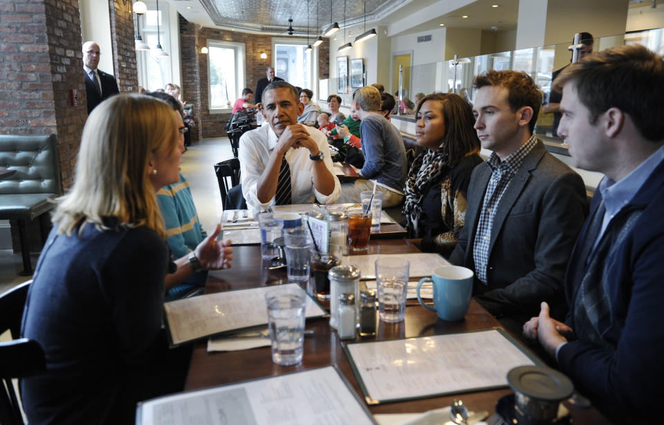 President Barack Obama listens as he has lunch with five young people at The Coupe restaurant in the Columbia Heights section of Washington, Friday, Jan. 10, 2014. The five are spearheading creative outreach efforts to connect with and help enroll young consumers through the Marketplaces or are interested in getting more involved with these efforts. Seated at the table with Obama are, from left, Anne Johnson, Andres Cruz, Obama, Jasmine Hicks, Tommy McFly and David Dimock. (AP Photo/Susan Walsh)