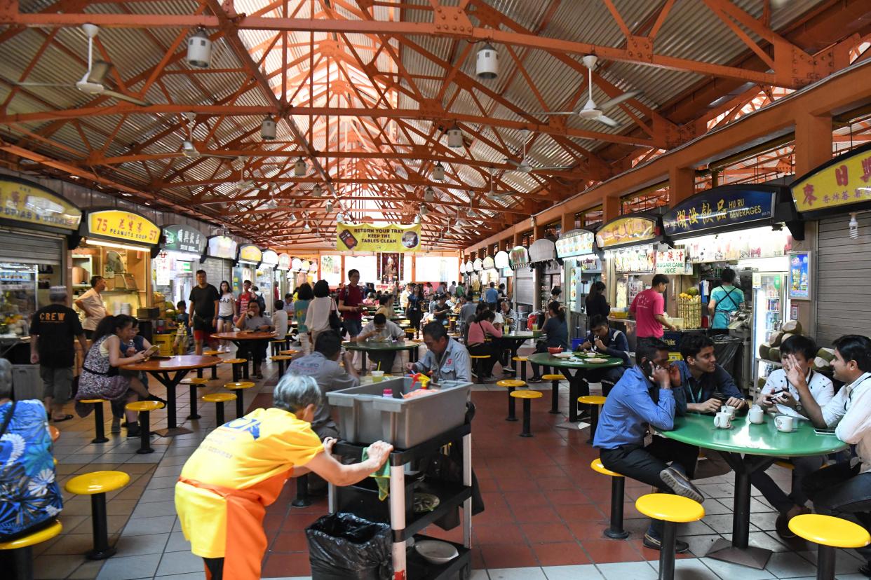 People have their lunch at the Maxwell hawkers centre in Singapore on August 30, 2018. - Singapore's bid to get UN recognition for its street food has sparked a cross-border culinary clash, with angry chefs in neighbouring Malaysia pouring cold water on the idea. (Photo by Roslan RAHMAN / AFP) / To go with AFP story:Singapore-Malaysia-UN-food-lifestyle        (Photo credit should read ROSLAN RAHMAN/AFP/Getty Images)