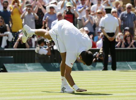 Novak Djokovic of Serbia pats the grass after winning his match against Philipp Kohlschreiber of Germany at the Wimbledon Tennis Championships in London, June 29, 2015. REUTERS/Suzanne Plunkett