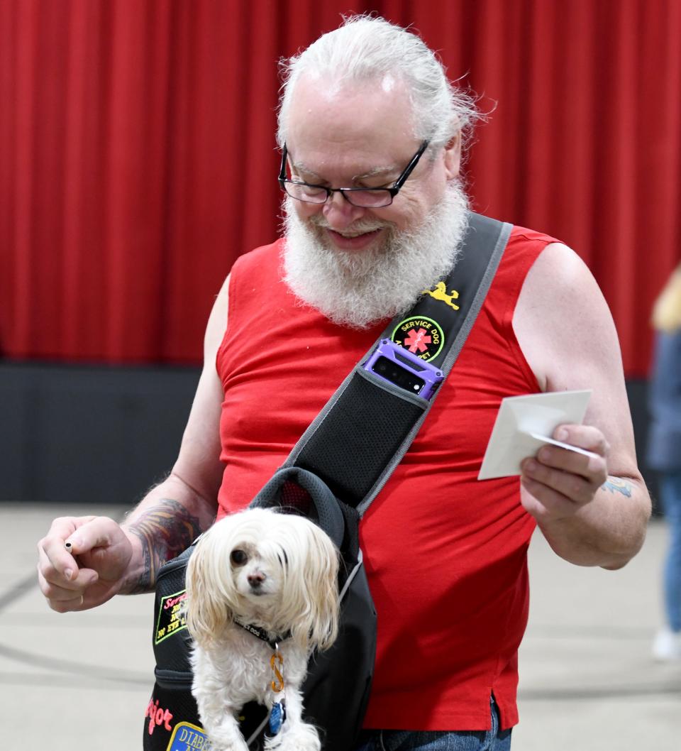 Dan Gogol with his dog, Major, casts his vote at Westbrook Park United Methodist Church in Canton on Aug. 8.