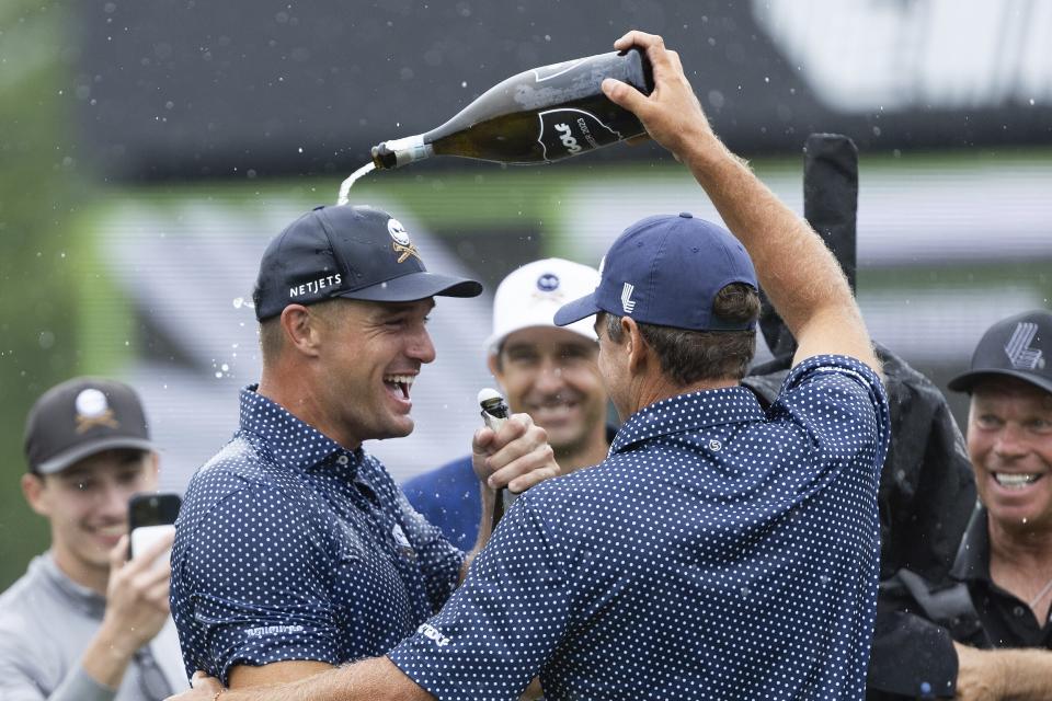 Captain Bryson DeChambeau, front left, of Crushers GC, and Charles Howell III, also of Crushers GC, celebrate on the 18th green during the final round of LIV Golf Greenbrier at The Old White at The Greenbrier, Sunday, Aug. 6, 2023 in White Sulfur Springs, W.Va. (Sam Greenwood/LIV Golf via AP)