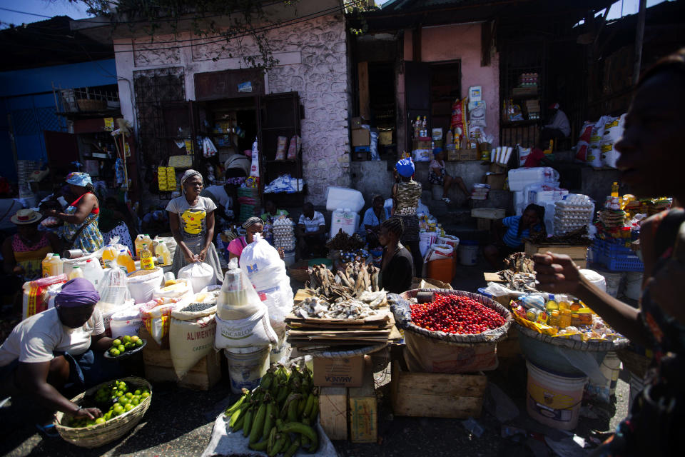 Vendors wait for clients at an open-air market in Port-au-Prince, Haiti, Monday, Feb. 18, 2019. Businesses and government offices slowly reopened across Haiti on Monday after more than a week of violent demonstrations over prices that have doubled for food, gas and other basic goods in recent weeks and allegations of government corruption. (AP Photo/Dieu Nalio Chery)