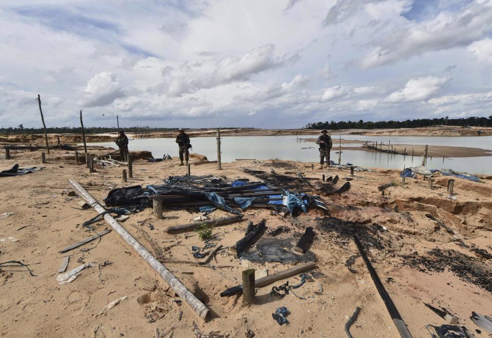 Policías peruanos resguardan un área deforestada por minería ilegal de oro en la provincia Madre de Dios de Perú el martes 19 de febrero de 2019. (Cris Bouroncle/Pool foto via AP)