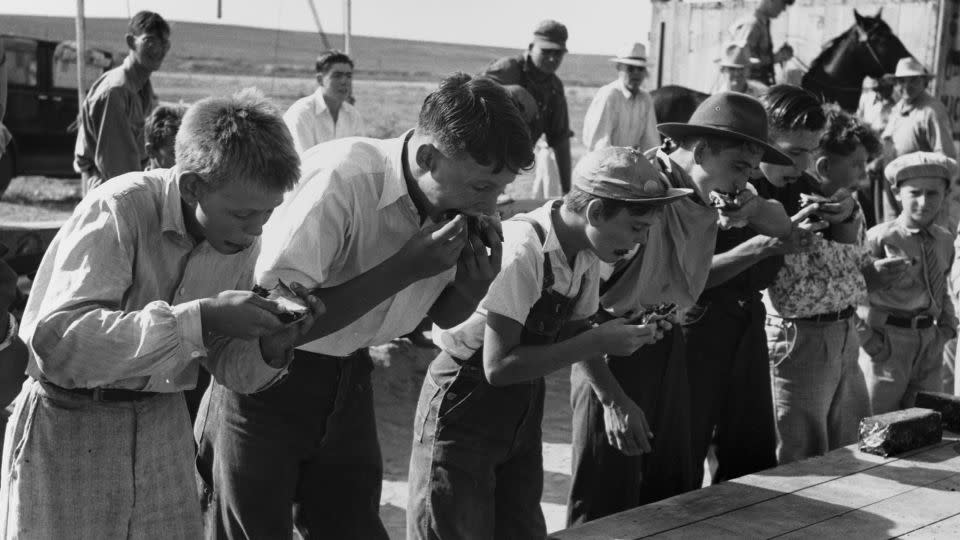 Boys participating in a pie eating contest at the 4-H Club fair in Cimarron, Kansas. August 1939. - Corbis/Getty Images