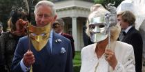 <p>Prince Charles and Camilla hold up metallic animal masquerade masks while at a charity event in London.</p>