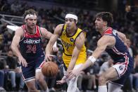 Indiana Pacers guard Andrew Nembhard (2) goes to the basket against Washington Wizards forward Corey Kispert (24) and forward Deni Avdija, right, during the first half of an NBA basketball game, Friday, Dec. 9, 2022, in Indianapolis. (AP Photo/Darron Cummings)