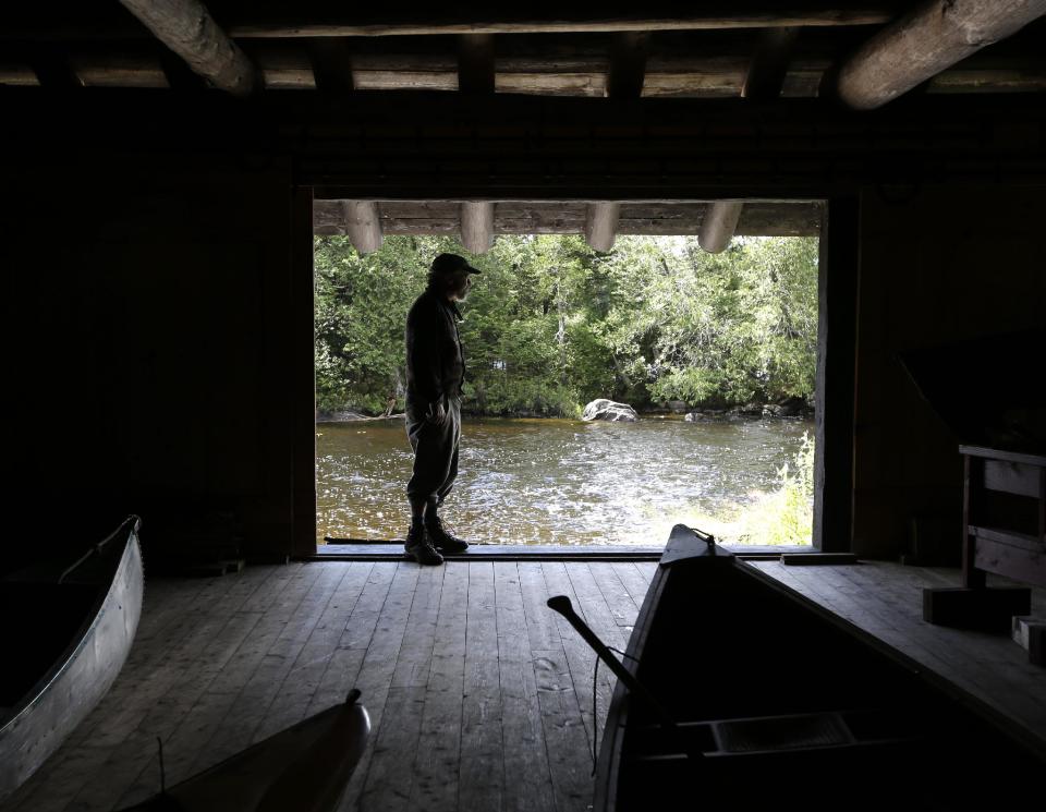 In this Tuesday, July 30, 2013 photo, master carpenter Michael Frenette poses in the boathouse at Camp Santanoni, an Adirondack great camp that is being restored, in Newcomb, N.Y. Santanoni was one of the earliest great camps built by wealthy families with names like Rockefeller and Vanderbilt beginning in the late 19th century. Managed by state environmental officials, it is the only remaining great camp that is publicly owned. (AP Photo/Mike Groll)