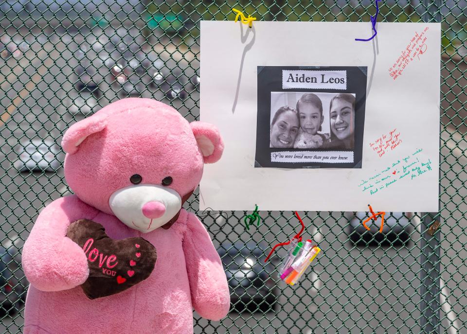 A large stuffed toy bear and a poster board with a photo and notes are part of a memorial for Aiden Leos, the 6-year-old boy who was shot and killed during a suspected road-rage attack in Southern California in late May.