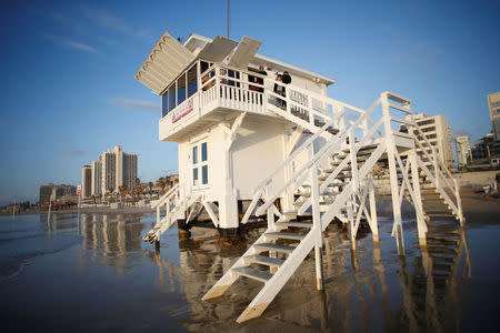 People help decorate a lifeguard tower as it is renovated into a luxury hotel suite, as part of an international online competition, at Frishman Beach in Tel Aviv, Israel March 13, 2017. Picture taken March 13, 2017. REUTERS/Baz Ratner