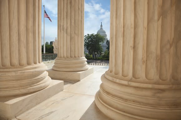 Marble columns and the U.S. Capitol Building in the background.