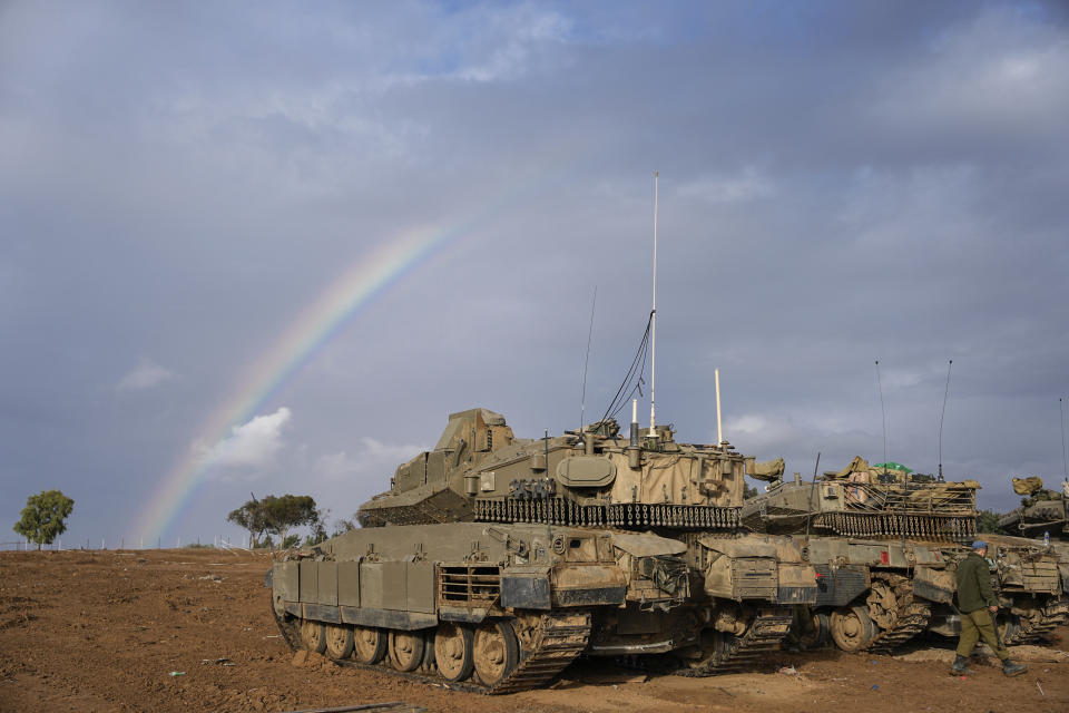 Israeli tanks are parked at an army staging area near Israel's border with Gaza, southern Israel, Monday, Nov. 27, 2023. on the fourth day of a temporary cease-fire between Israel and Hamas. (AP Photo/Ohad Zwigenberg)