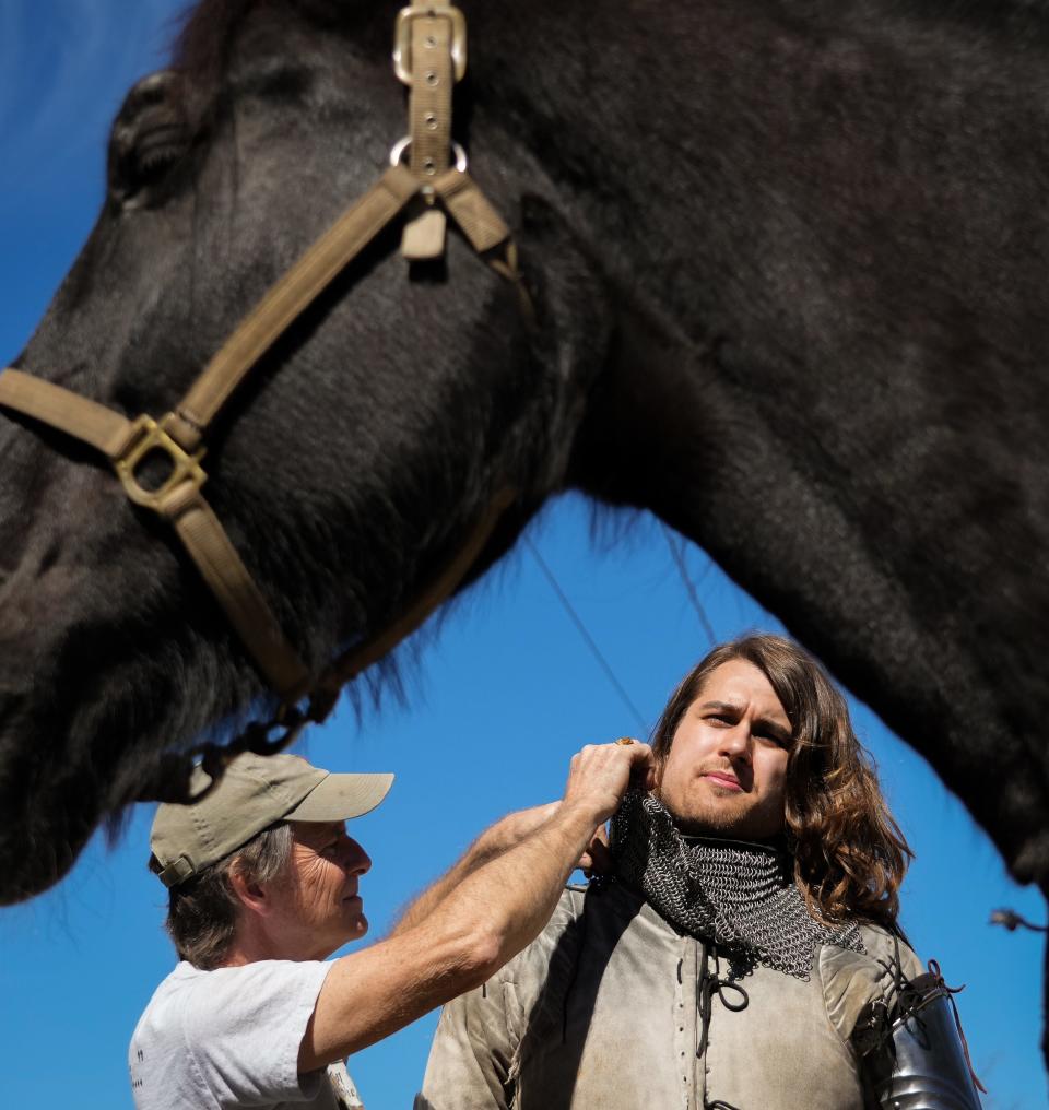 Raven Eastwood, right, gets help putting on his armor from jousting coach and organizer Steve Hemphill ahead of a practice session.