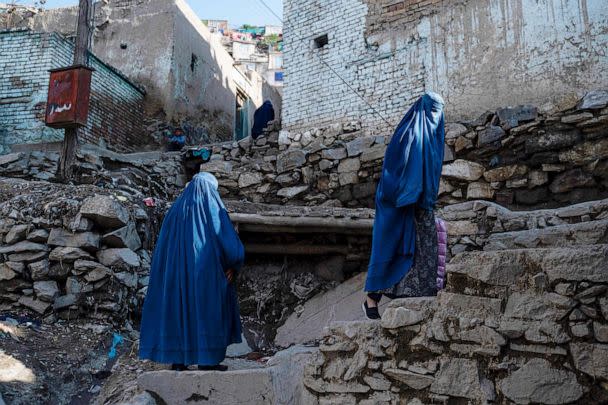 PHOTO: Afghan burqa-clad women climb a stony path in Kabul on April 6, 2023. (Wakil Kohsar/AFP via Getty Images)