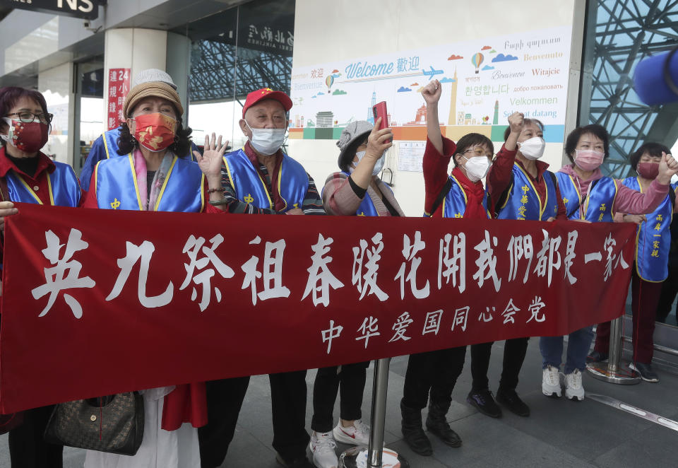 Supporters hold slogans reading ''Ma Ying-jeou Ancestor Worship. Spring blossoms. We Are All One Family'', as former Taiwan President Ma Ying-jeou leaves for China, outside of Taoyuan International Airport in Taoyuan City, northern Taiwan, Monday, March 27, 2023. Ma is scheduled to visit China Monday on a 12-day tour, a day after Taiwan lost another one of its diplomatic allies to China. (AP Photo/Chiang Ying-ying)(AP Photo/Chiang Ying-ying)