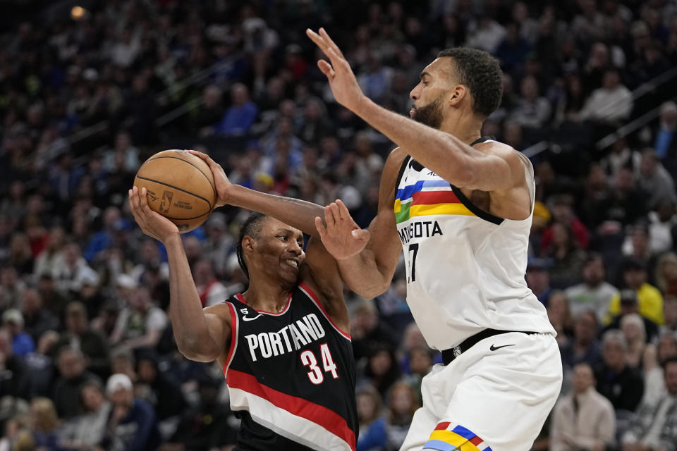 Portland Trail Blazers forward Jabari Walker (34) works towards the basket while defended by Minnesota Timberwolves center Rudy Gobert during the second half of an NBA basketball game, Sunday, April 2, 2023, in Minneapolis. (AP Photo/Abbie Parr)