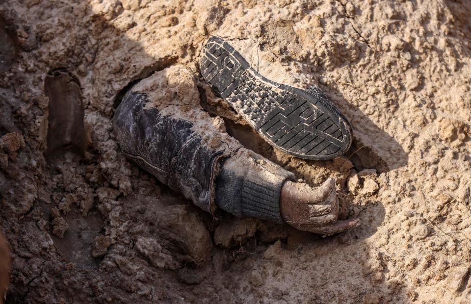 An arm and a shoe in a mass grave in Bucha on Thursday. 