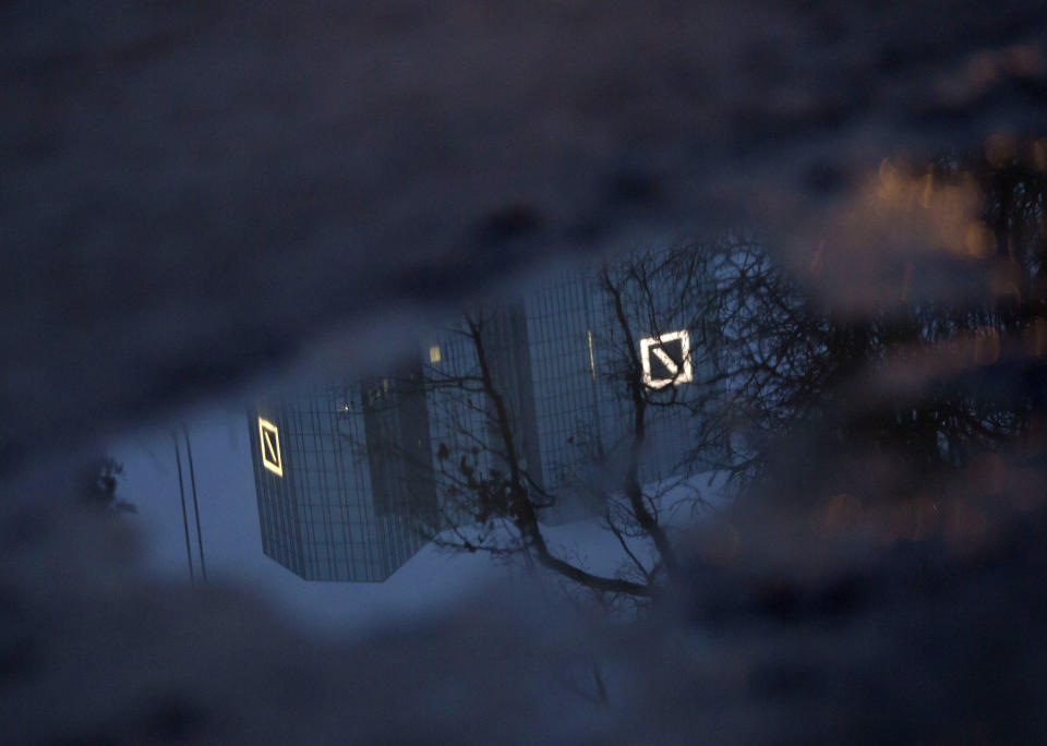 The Deutsche Bank headquarters is reflected in a puddle in Frankfurt, Germany, Monday, Jan. 20, 2014. Shares of Deutsche Bank AG have fallen sharply after Germany's biggest lender announced a large fourth-quarter net loss, its results weighed down by one-time expenses and losses on investments it is disposing of to strengthen its finances. The bank on Sunday night, Jan. 19, 2014 posted a fourth-quarter net loss of 965 million euros (US dollar 1.3 billion), an announcement that came 10 days before it was scheduled to release its results. (AP Photo/dpa, Frank Rumpenhorst)