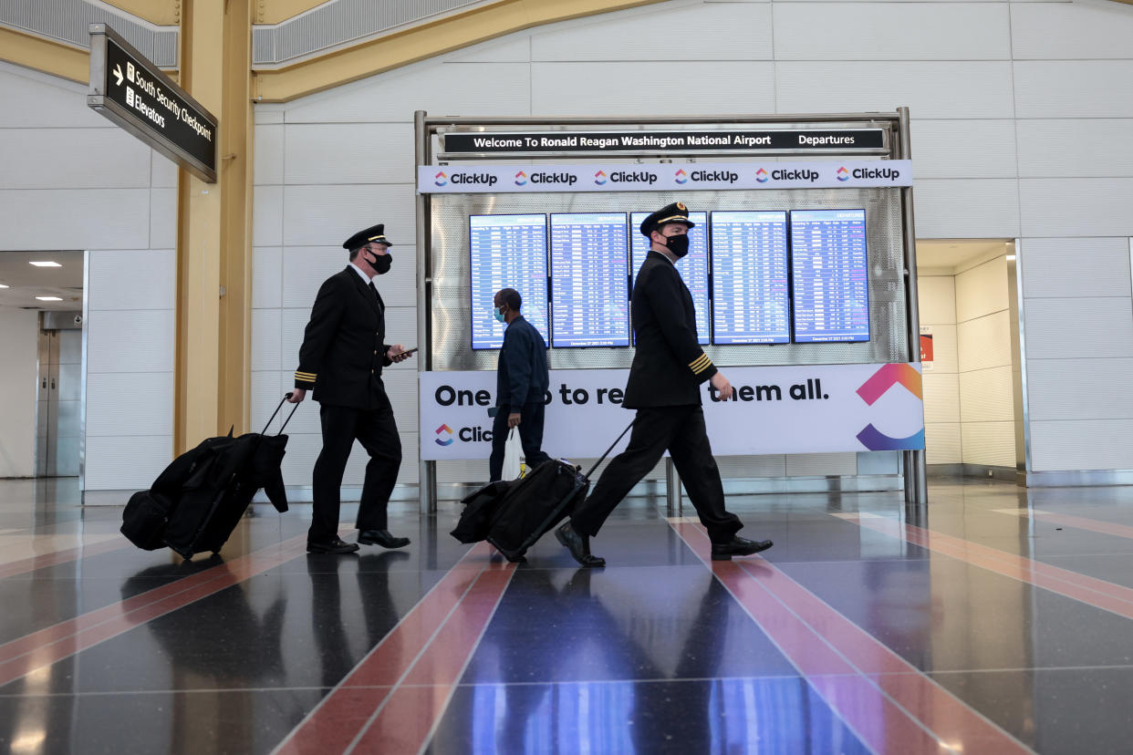 Airline pilots walk through the Ronald Reagan Washington National Airport on December 27, 2021 at Arlington, Virginia. (Photo by Anna Moneymaker/Getty Images)