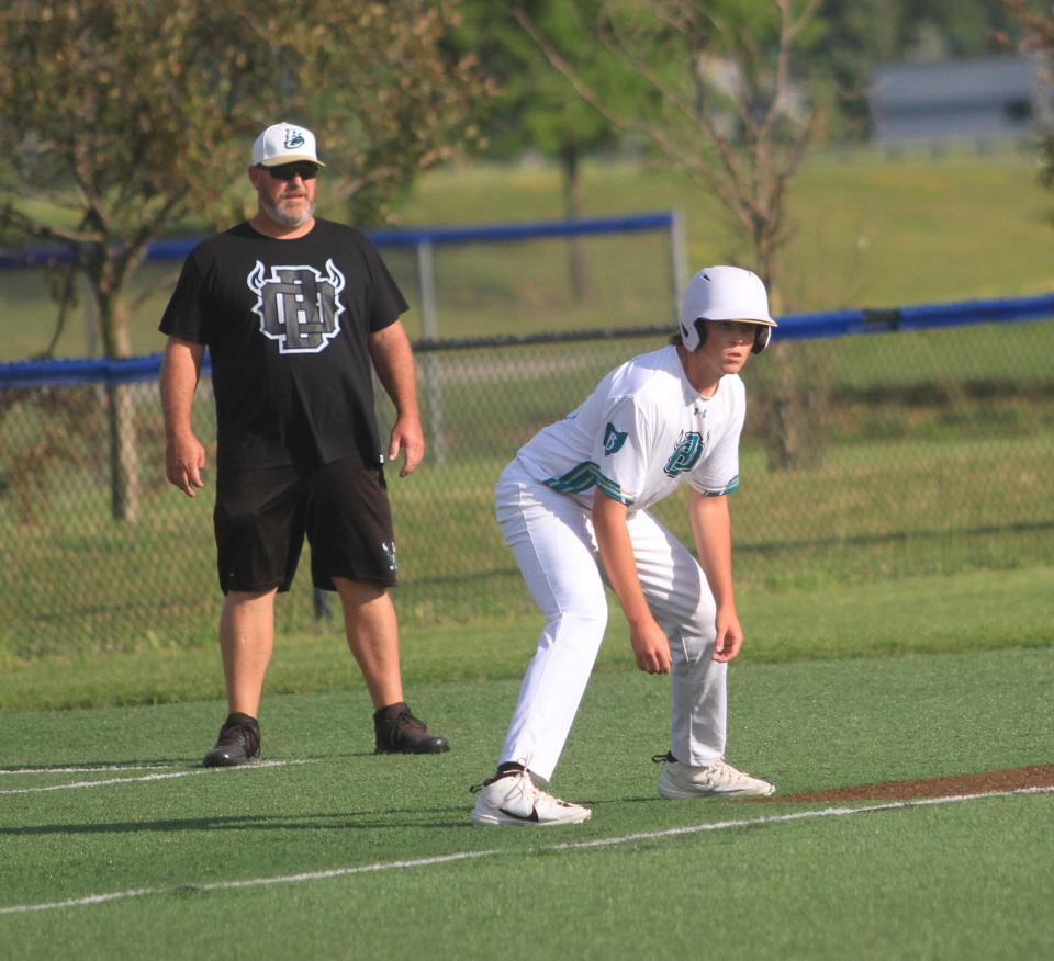 Lakewood's Mason Sprankle leads off from third base in front of coach Dustin Askew for the Ohio Bison 17U/18U in a 5-4 victory over the Dayton Sluggers 17U on Friday. Askew has coached the team since it started as the Licking County Outlaws at 9U.