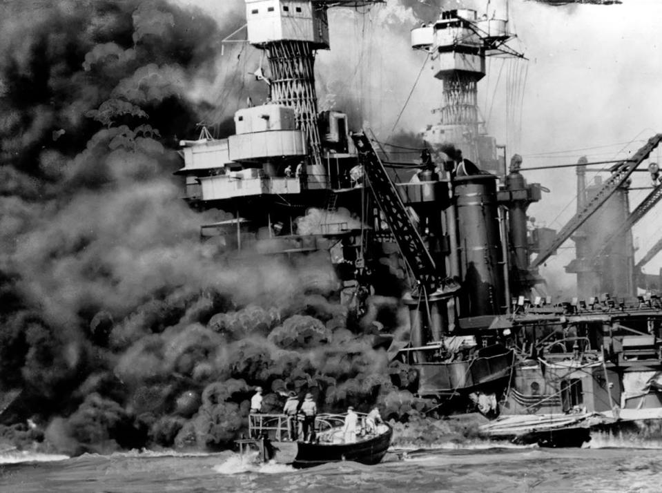 A rescue boat picks up a crewman from the burning USS West Virginia.