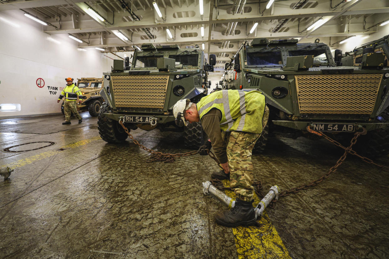 Foxhound armoured vehicles belonging to the 7 Light Mechanised Brigade unit of the British Army, aka 'The Desert Rats', are loaded by members of the Royal Logistics Corps' 17 Port & Maritime Regiment onto the MV Anvil Point, at Marchwood Military Sea Mounting Centre near Southampton, southern England, on February 13, 2024, as preparations are made for them to take part in military exercises in Europe under the NATO umbrella exercise, 'Steadfast Defender'. Some 90,000 NATO troops will take part in the months-long Steadfast Defender 24 exercise designed to test its defences in the face of Russia's war on Ukraine. The exercise is designed to simulate the 31-nation alliance's response to an attack from a rival like Russia. (Photo by Adrian DENNIS / AFP) (Photo by ADRIAN DENNIS/AFP via Getty Images)