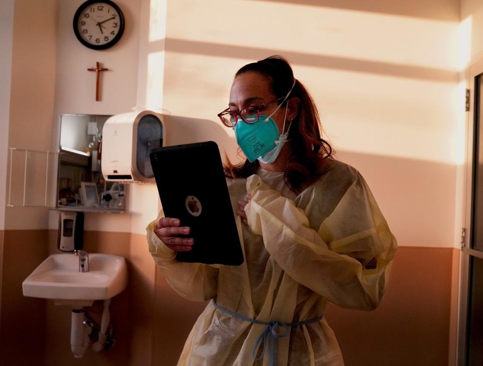 Dr. Marwa Kilani, a hospice and palliative medicine specialist at Providence Holy Cross Medical Center, does a video call with a patient's daughter on Wednesday, Feb. 10, 2021. She is responsible for updating families on her patients' conditions because no visitors are allowed during the pandemic. "It's traumatic to hear families on the other end, tearful and crying," Kilani said. "COVID is a whole different beast and we've had to jump in and move forward as best we can."