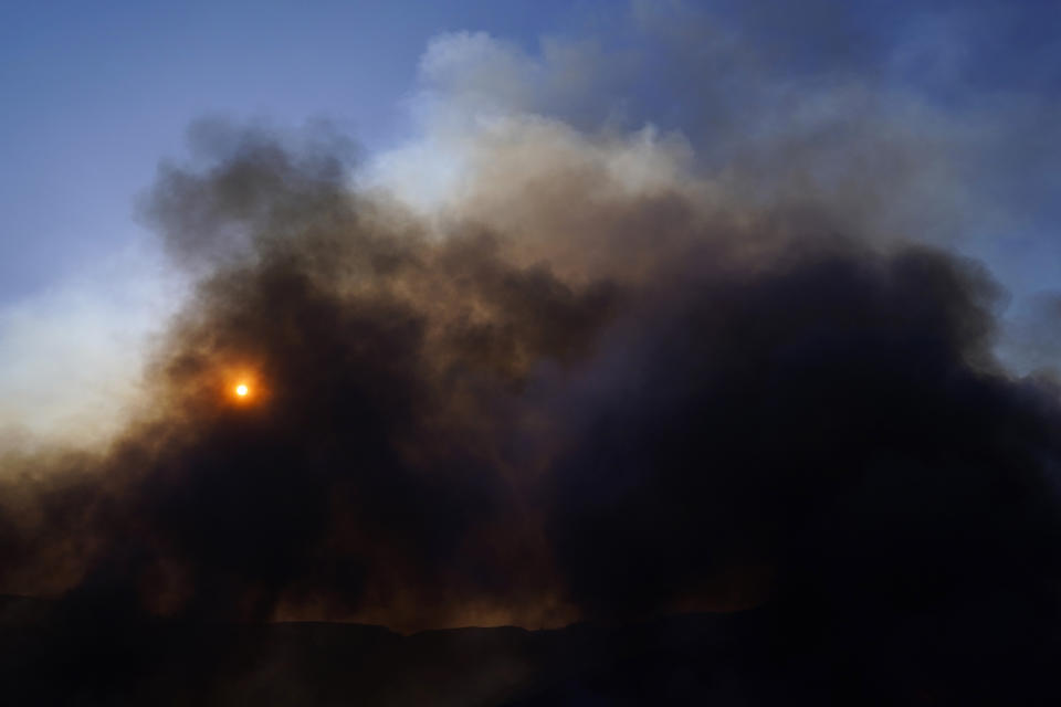 The sun is visible through thick smoke generated by the Blue Ridge Fire Tuesday, Oct. 27, 2020, in Chino Hills, Calif. Crews tried to beat back two out-of-control wildfires in Southern California on Tuesday that have kept tens of thousands of people out of their homes even as another round of dangerous fire weather raises the risk for flames erupting across the state. (AP Photo/Jae C. Hong)