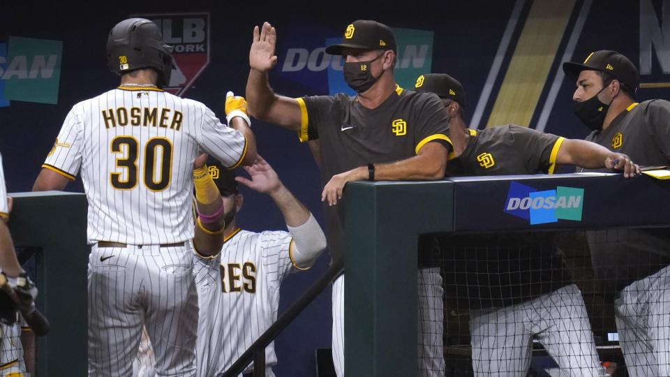 San Diego Padres' Eric Hosmer (30) is congratulated by teammates after scoring on a bases-loaded walk to Jake Cronenworth during the second inning in Game 3 of a baseball National League Division Series Thursday, Oct. 8, 2020, in Arlington, Texas. (AP Photo/Sue Ogrocki)