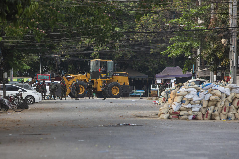 Police and military occupy a roadblock in Yangon, Myanmar, Friday, March 19, 2021. The authorities in Myanmar have arrested a spokesman for ousted leader Aung San Suu Kyi's political party as efforts to restrict information about protests against last month's military takeover are tightened. (AP Photos)