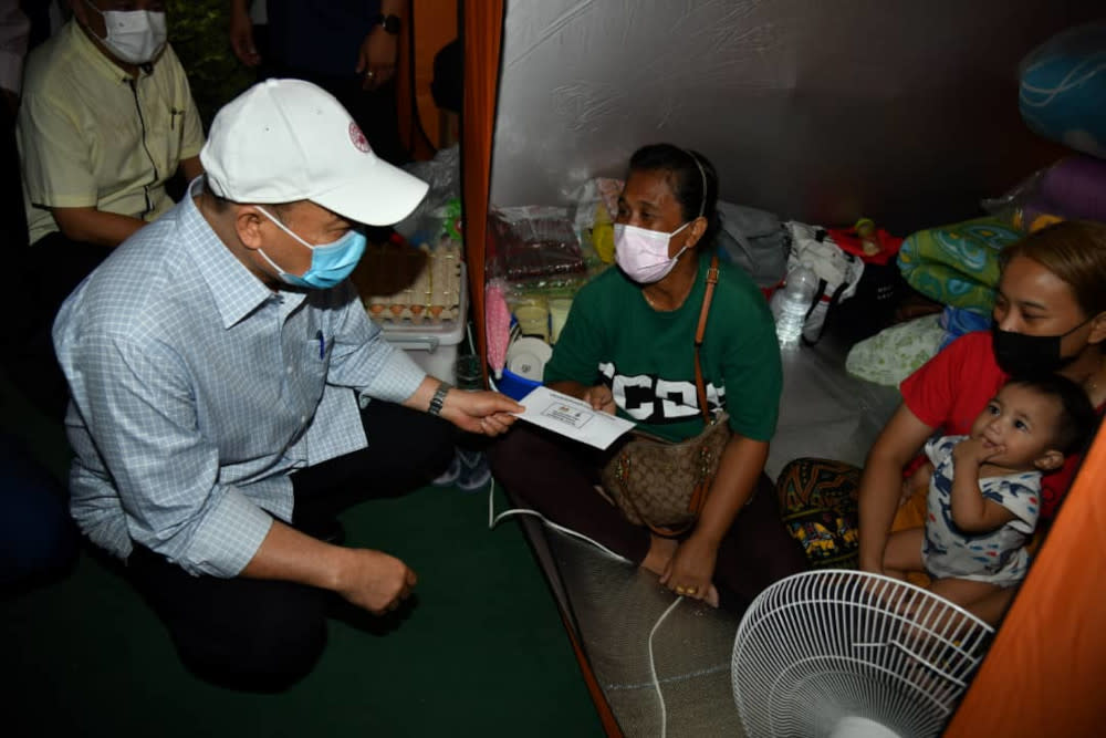 Sabah Chief Minister Datuk Hajiji Noor meeting some of the victims of the fire in Kampung Meruntum last Saturday which saw 35 wooden stilt homes razed. — Picture by Julia Chan