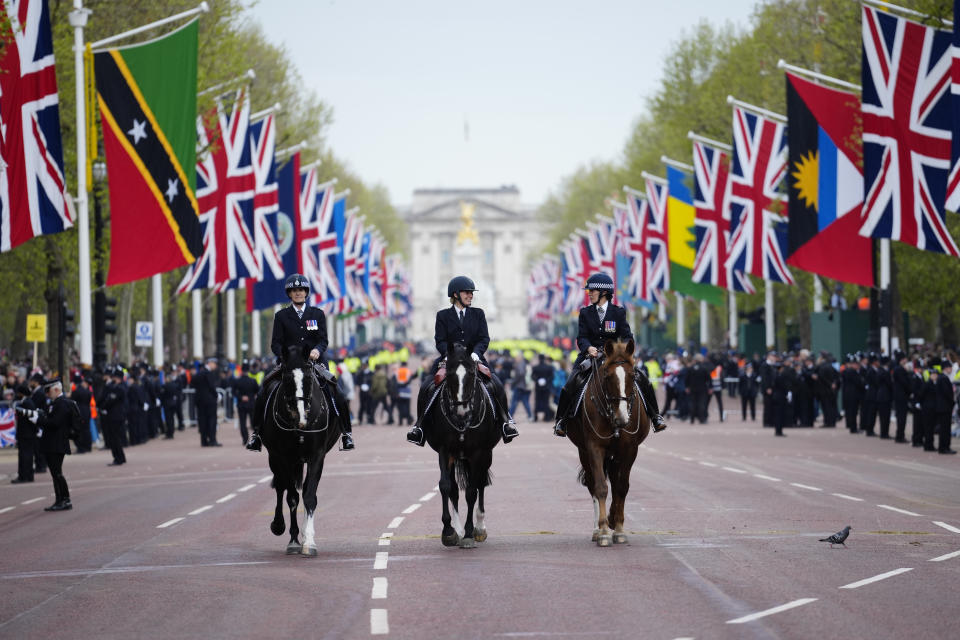 Flags fly as police ride down The Mall