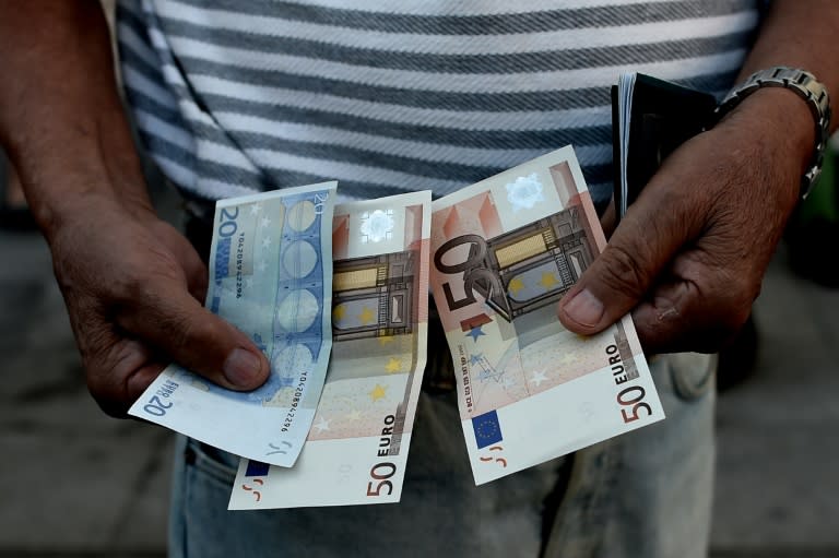 A Greek pensioner holds 120 euros outside a national bank branch in Athens, on July 1, 2015