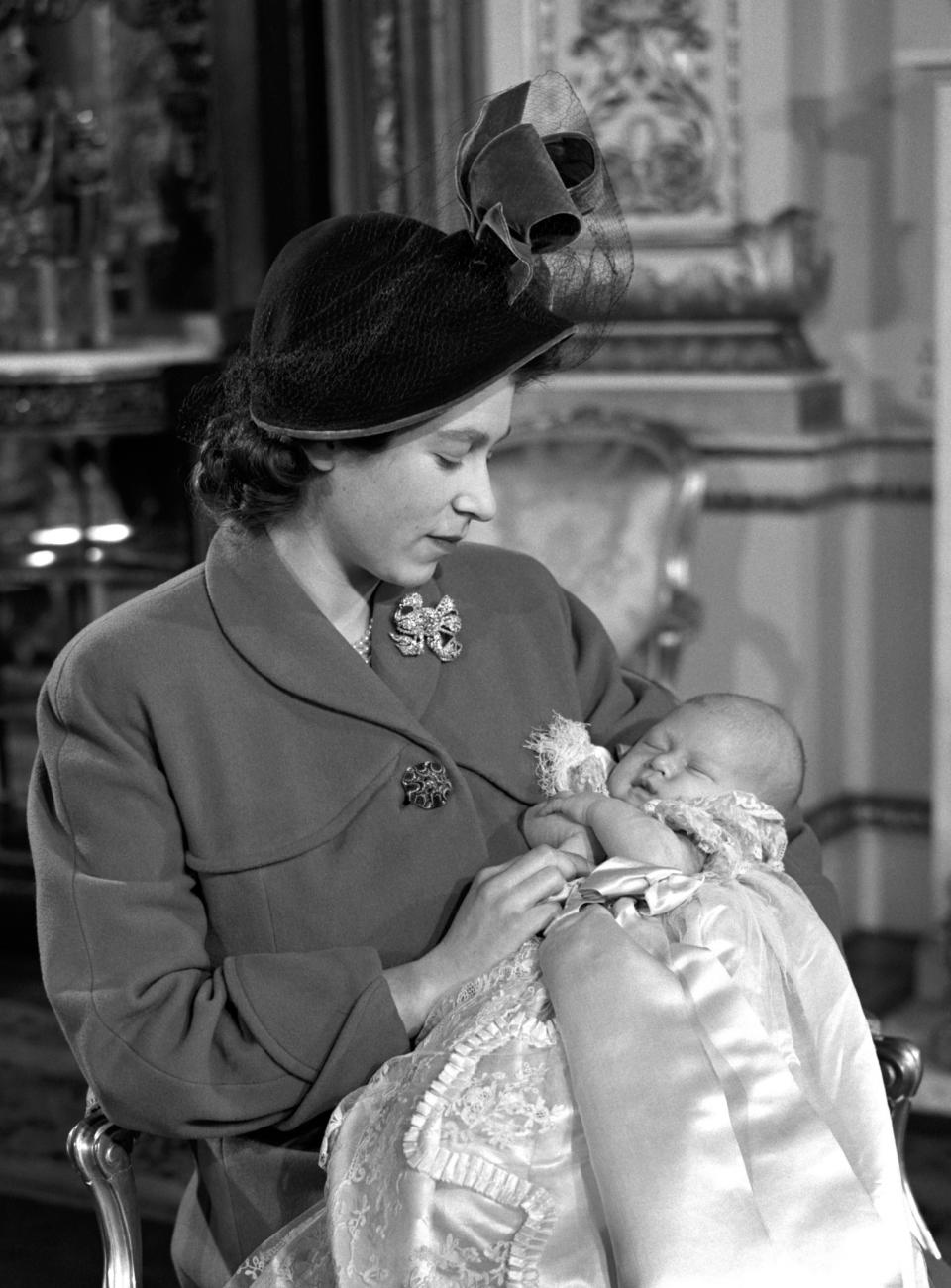 <p>Princess Elizabeth holds her son Prince Charles after his Christening ceremony in Buckingham Palace (PA Archive) </p>