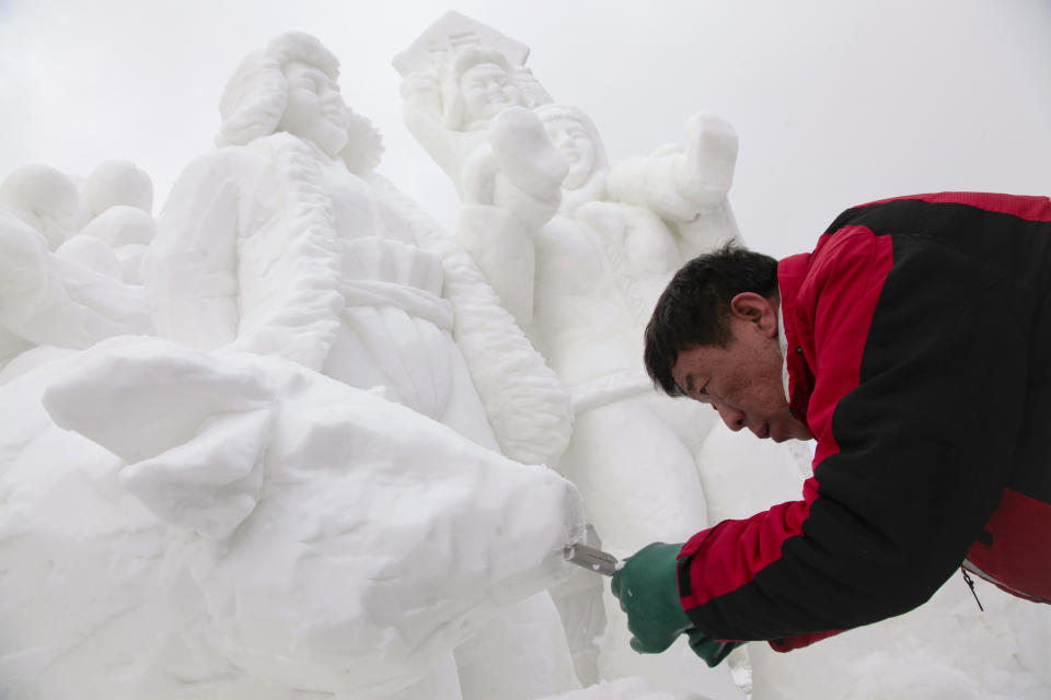 The captain of Team China, Hongchun Liang carving away snow to make the mouth of a cow on his 12 foot tall, 20-ton sculpture at the outdoor art gallery during the 23rd Annual International Snow Sculpture Championships in Breckenridge, Colo., on Friday, Jan. 25, 2013. Liang is joined with 15 international teams, the sculptures will remain on display through Feb. 3, 2013 (weather permitting). Visit www.gobreck.com for more information. (Nathan Bilow / AP Images for The Breckenridge Resort Chamber)