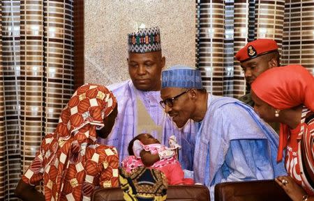 Amina Ali Darsha Nkeki, a Nigerian schoolgirl rescued after over two years of captivity with Boko Haram militants, presents her child to President Muhammadu Buhari in Abuja, Nigeria May 19, 2016. REUTERS/Afolabi Sotunde