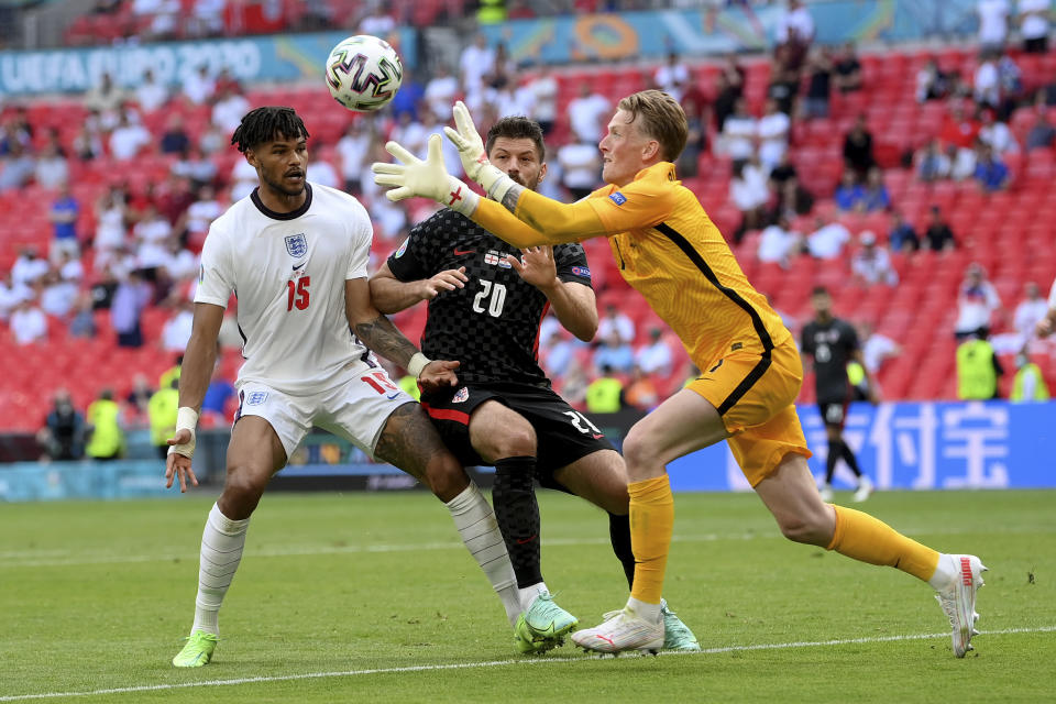 England's goalkeeper Jordan Pickford, right, goes for the ball ahead of England's Tyrone Mings, left, and Croatia's Bruno Petkovic during the Euro 2020 soccer championship group D match between England and Croatia, at Wembley stadium, London, Sunday, June 13, 2021. (Laurence Griffiths, Pool via AP)