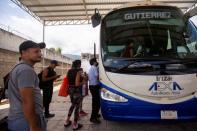 FILE PHOTO: Migrants who left a caravan, after receiving documents to cross the country, wait to board a bus, in Huixtla