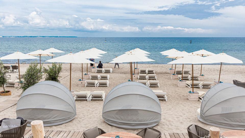 Strandliegen und Sonnenschirme stehen in Timmendorfer-Strand für Badegäste bereit.