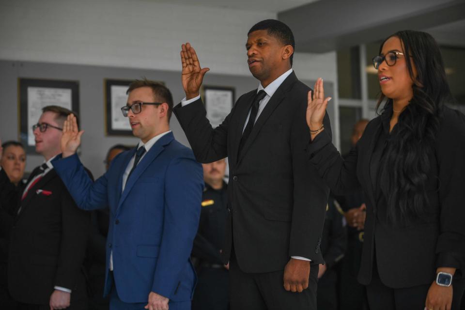 Soon-to-be deputies raise their hand as they recite an oath during the Jackson Police Department deputy swear-in inside the JPD Headquarters on Tuesday, Feb. 19, 2024.
