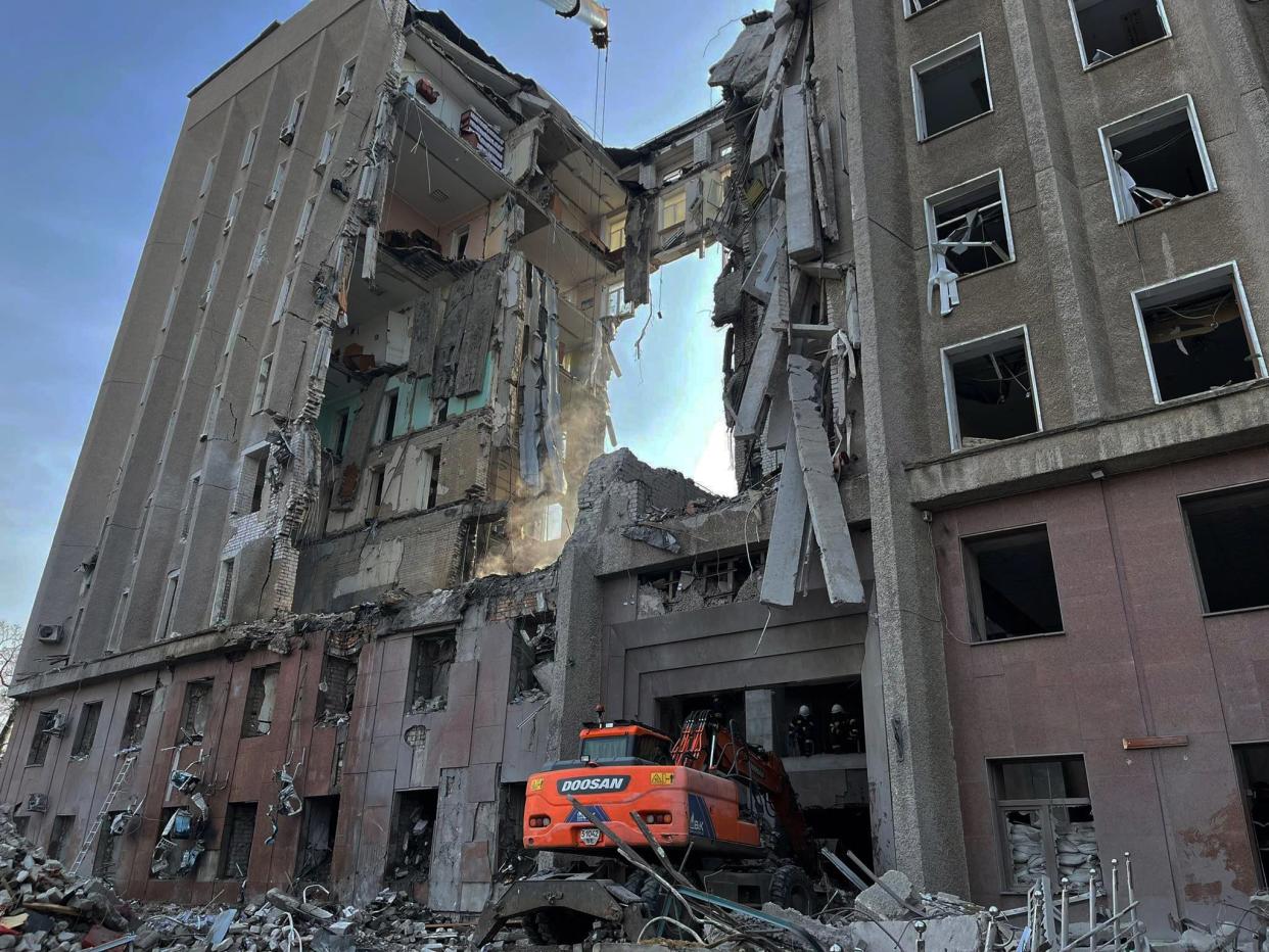 This handout picture released on March 30, 2022 by the State Emergency Service of Ukraine shows rescuers conducting search operations and dismantling the debris of a government building in Mykolaiv, which was hit by Russian rockets the previous day. 