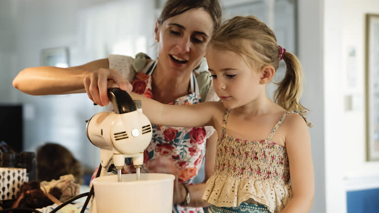 Mother and daughter using mixer