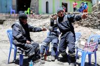 Artisanal gold miners drink beer on a street in La Rinconada, in the Andes