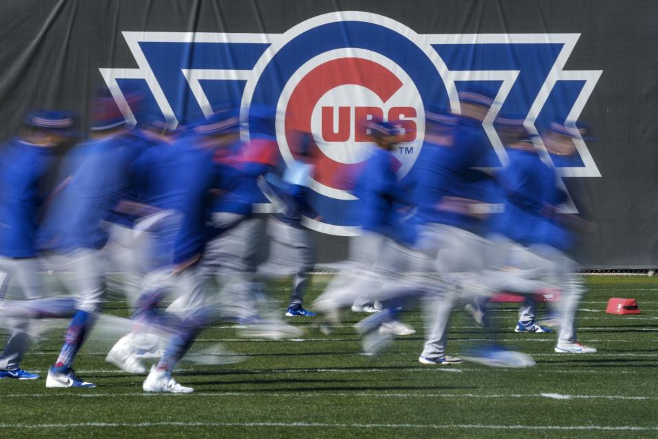 Some Chicago Cubs players run during a spring training baseball workout Wednesday, Feb. 15, 2023, in Mesa. (AP Photo/Morry Gash)