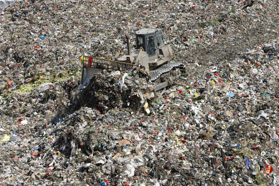 A bulldozer evens out garbage at a waste landfill site in Hangzhou, Zhejiang province March 11, 2010.  REUTERS/Steven Shi (CHINA - Tags: ENVIRONMENT)